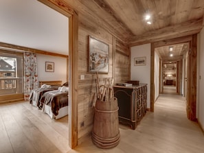 A wooden interior with a bed, a wooden barrel, and a framed picture on the wall.