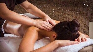 A person receiving a back massage in a room with a textured wall and a white towel on the massage table. - Male Massage therapist for colombo with A/C comfortable room (Colombo)