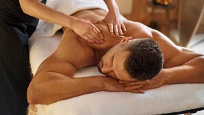 A massage therapy session in a spa setting with a client lying face down on a massage table, receiving a back massage from a therapist. - Male Massage therapist for colombo with A/C comfortable room (Colombo)