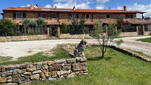 A stone building with a tiled roof, a stone lion statue, and a gravel driveway. - Relaxation in the Tuscan hills Typical Tuscan farmhouse, app.MIELE (Collesalvetti)