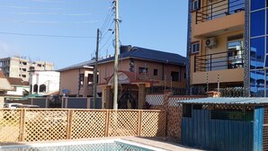 Piscina rodeada de edificios residenciales y una valla de madera.