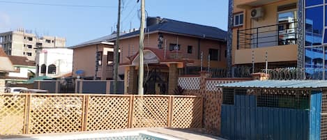 A swimming pool with a wooden fence, surrounded by residential buildings.