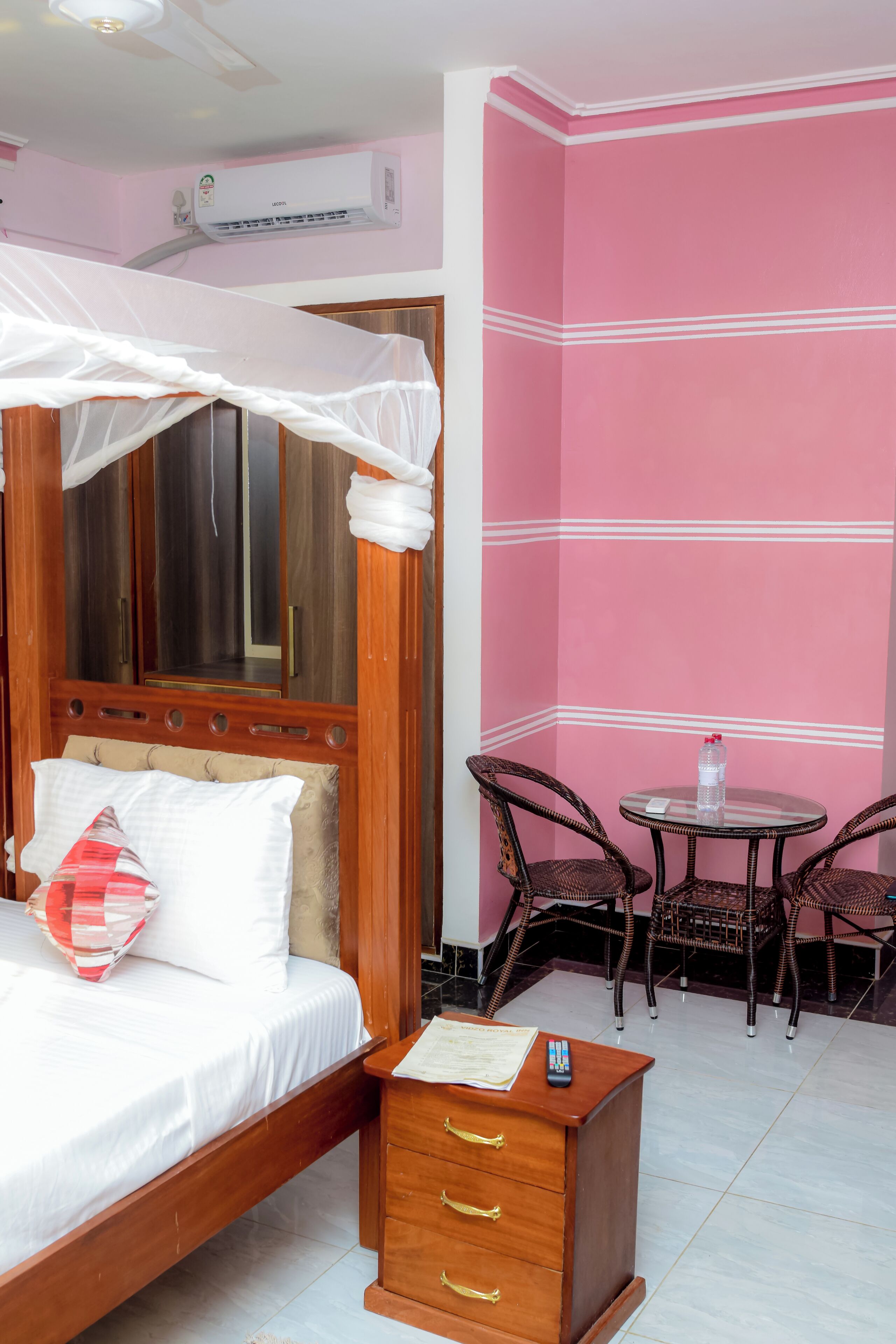 Un dormitorio con cama, mesita de noche y una pequeña mesa redonda con sillas.