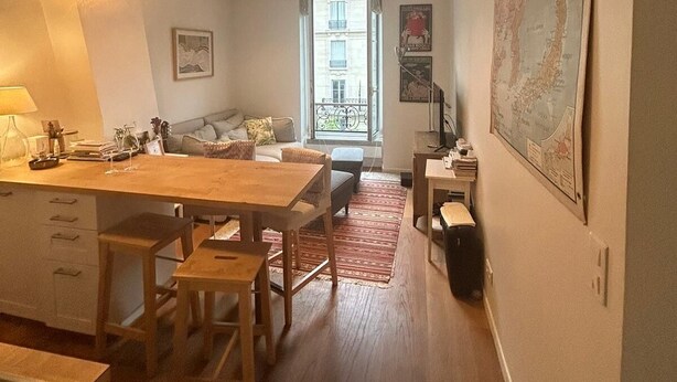 Un espacio habitable compacto con cocina, comedor y un conjunto de sofás.