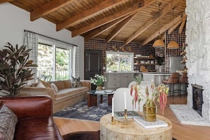 A modern living room with a leather sofa, a round coffee table, and a fireplace.