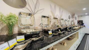 Un buffet avec différents récipients contenant de la nourriture et des ustensiles de service.