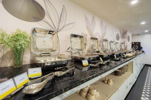 A buffet setup with various food containers and serving utensils. - Hotel Limon Sector 45 Gurgaon (Gurugram)
