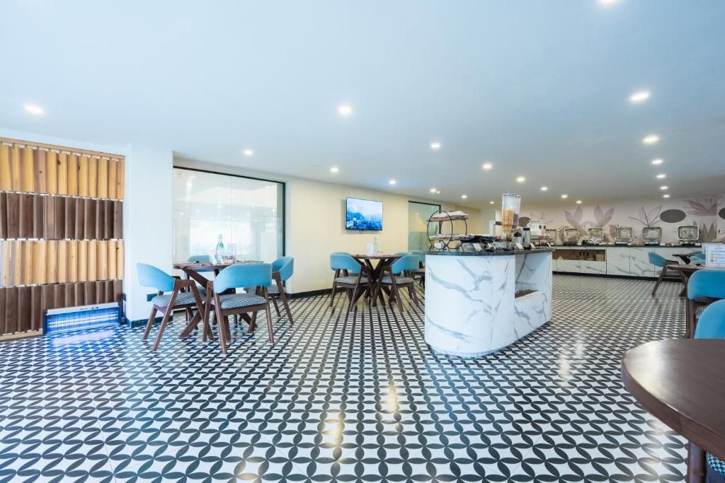 Un intérieur moderne avec un sol à motifs, un espace de repas central doté de chaises et une cuisine avec un îlot en marbre.