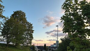 Eine Wohnstraße mit Häusern, einem parkenden Auto und einer Straßenlaterne.