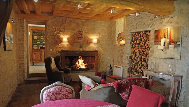 A cozy room with a fireplace, wooden beams, and rustic decor.