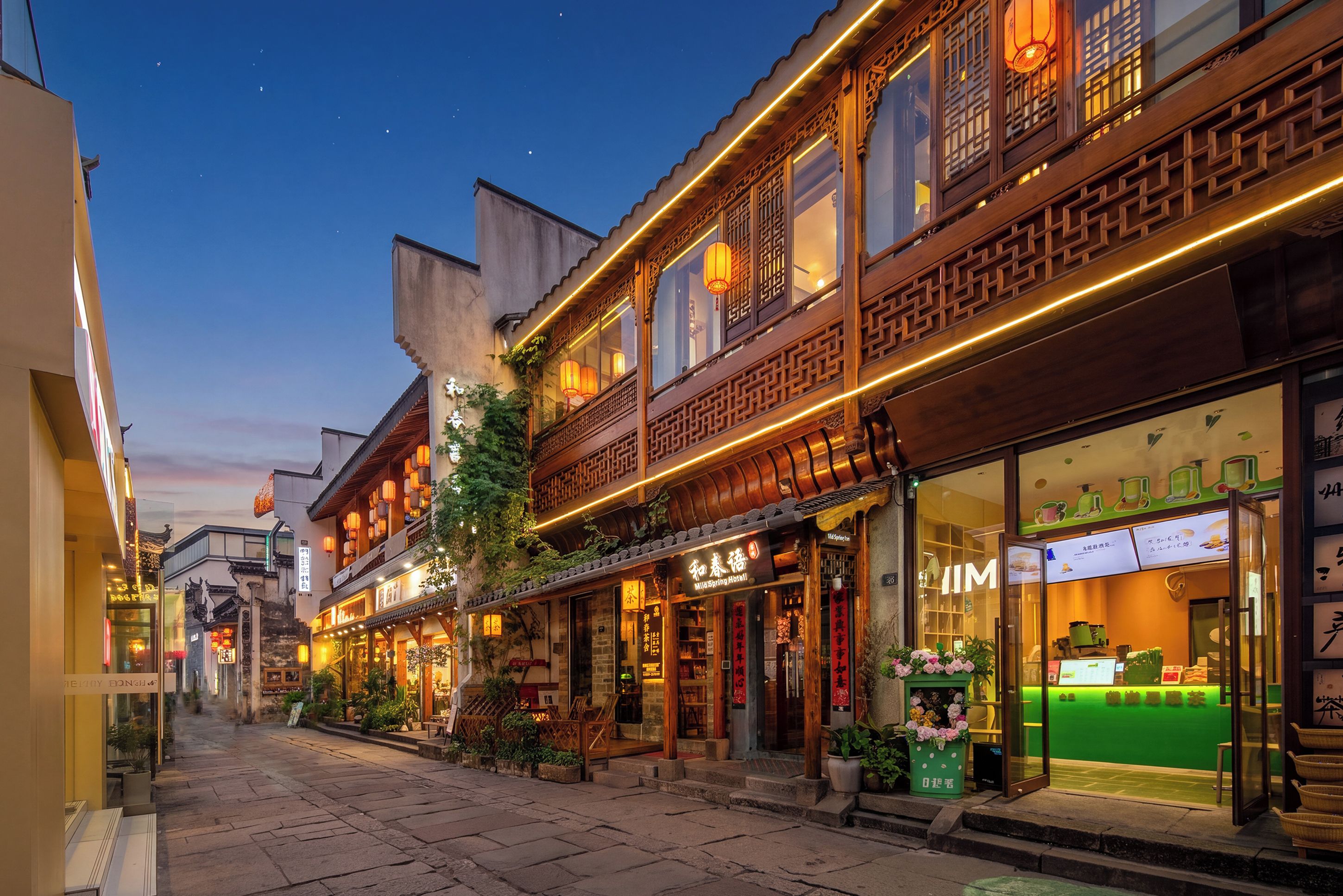 A traditional building with a restaurant on the ground floor, a visible sign for a hotel, and a green awning.