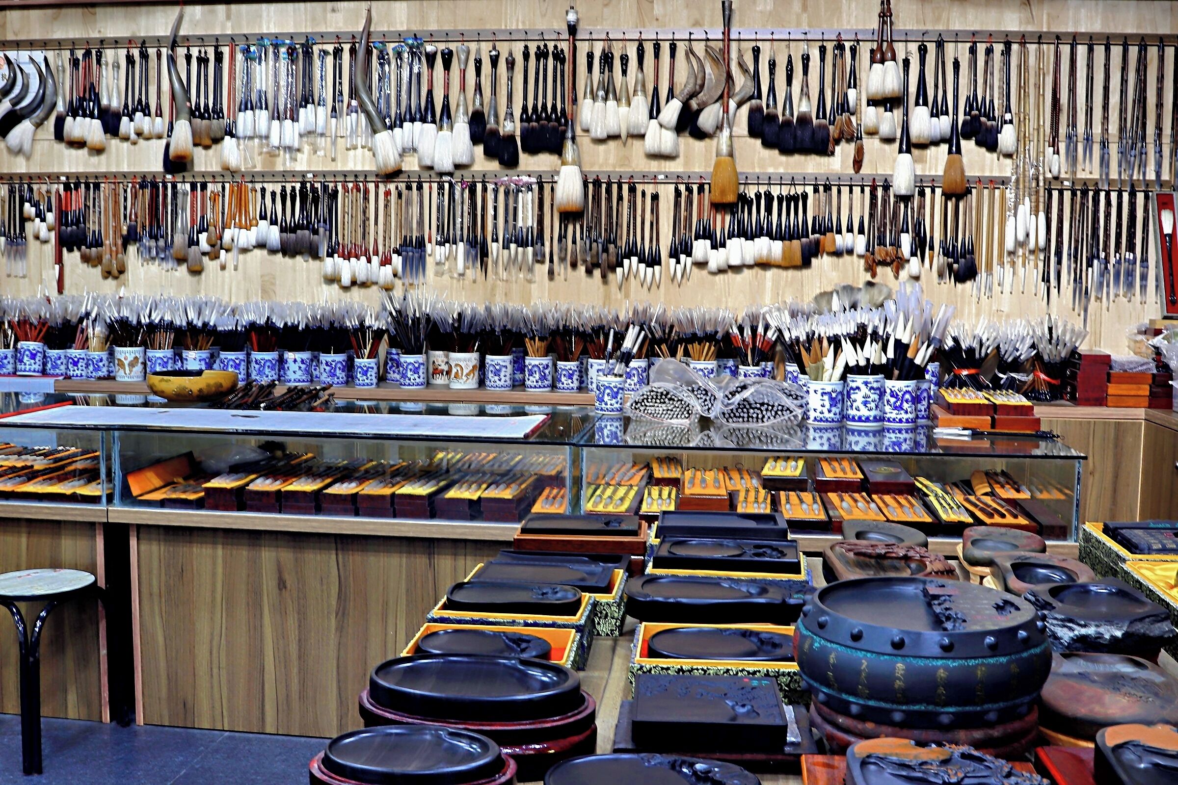 A display of various traditional tools and utensils, including knives, chopsticks, and bowls, arranged on shelves and tables.