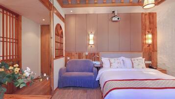 A bedroom with a wooden headboard, a bed with white bedding, a purple armchair, and a wooden bench.