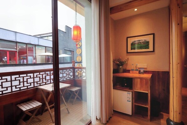 A room with a wooden table and chairs, a small cabinet, and a framed picture on the wall.