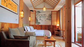 A traditional Japanese-style room with a bed, sofa, and a dining area.