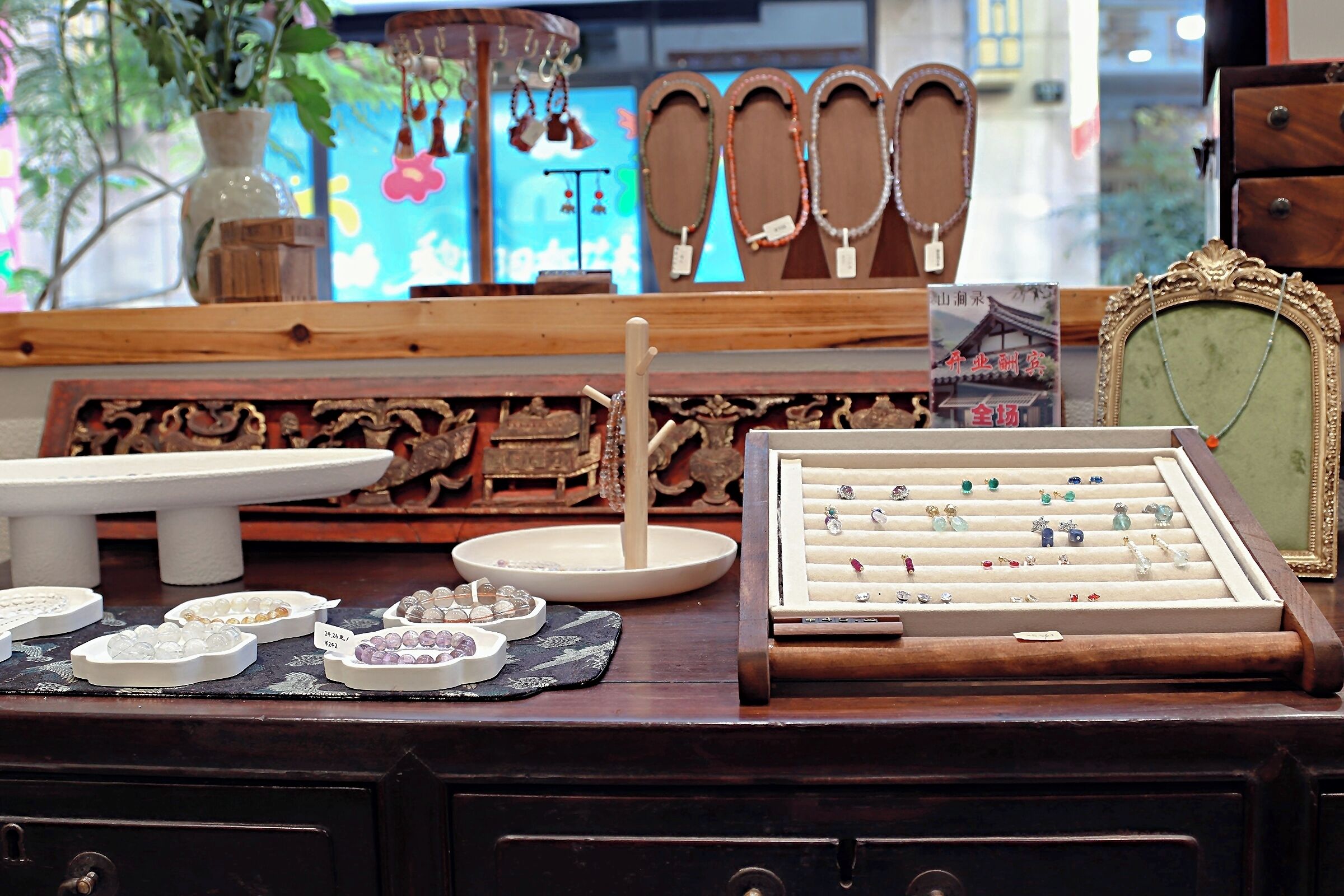 Un présentoir à bijoux avec différents articles exposés sur un comptoir en bois.