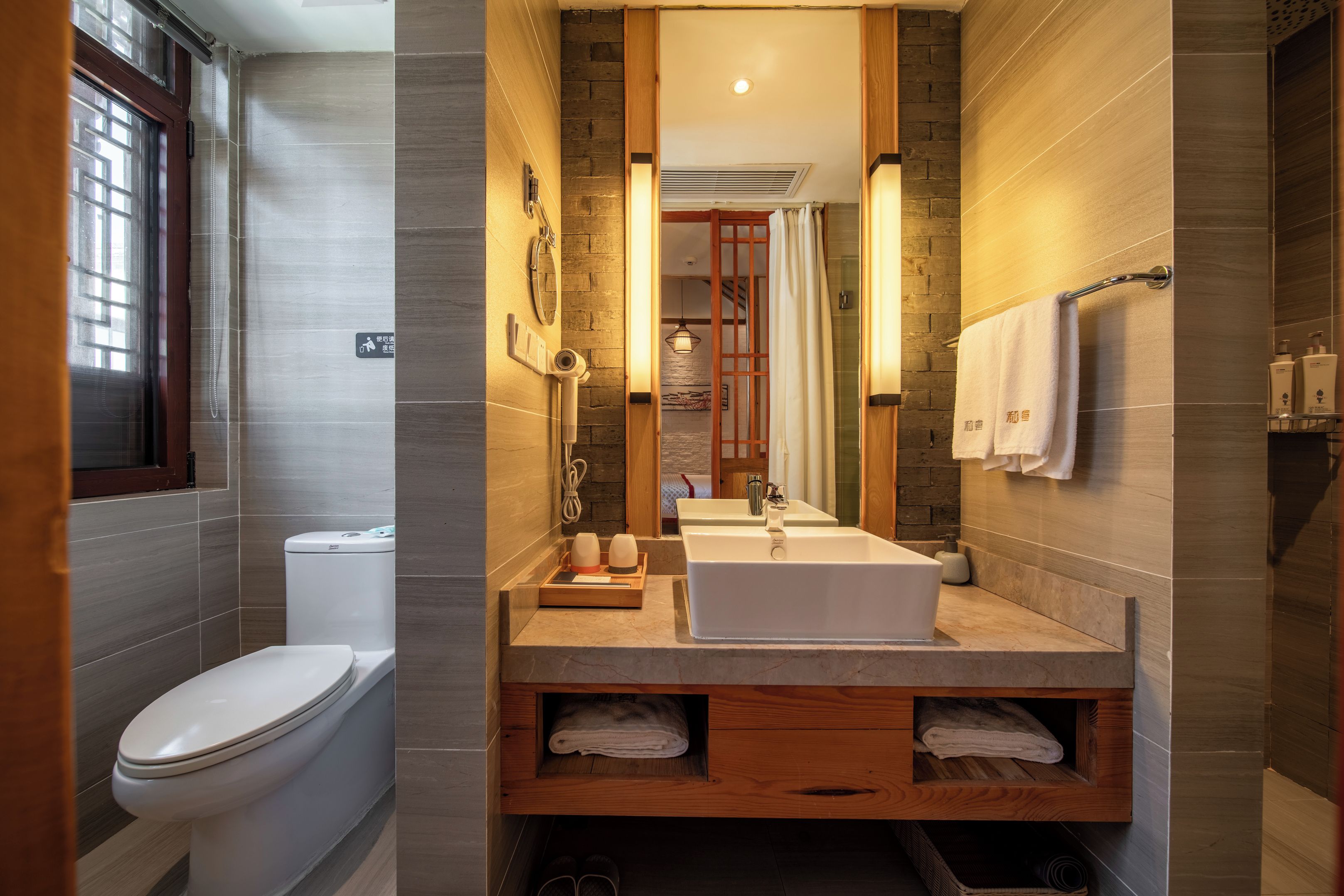 Un baño moderno con inodoro, lavabo y espejo.