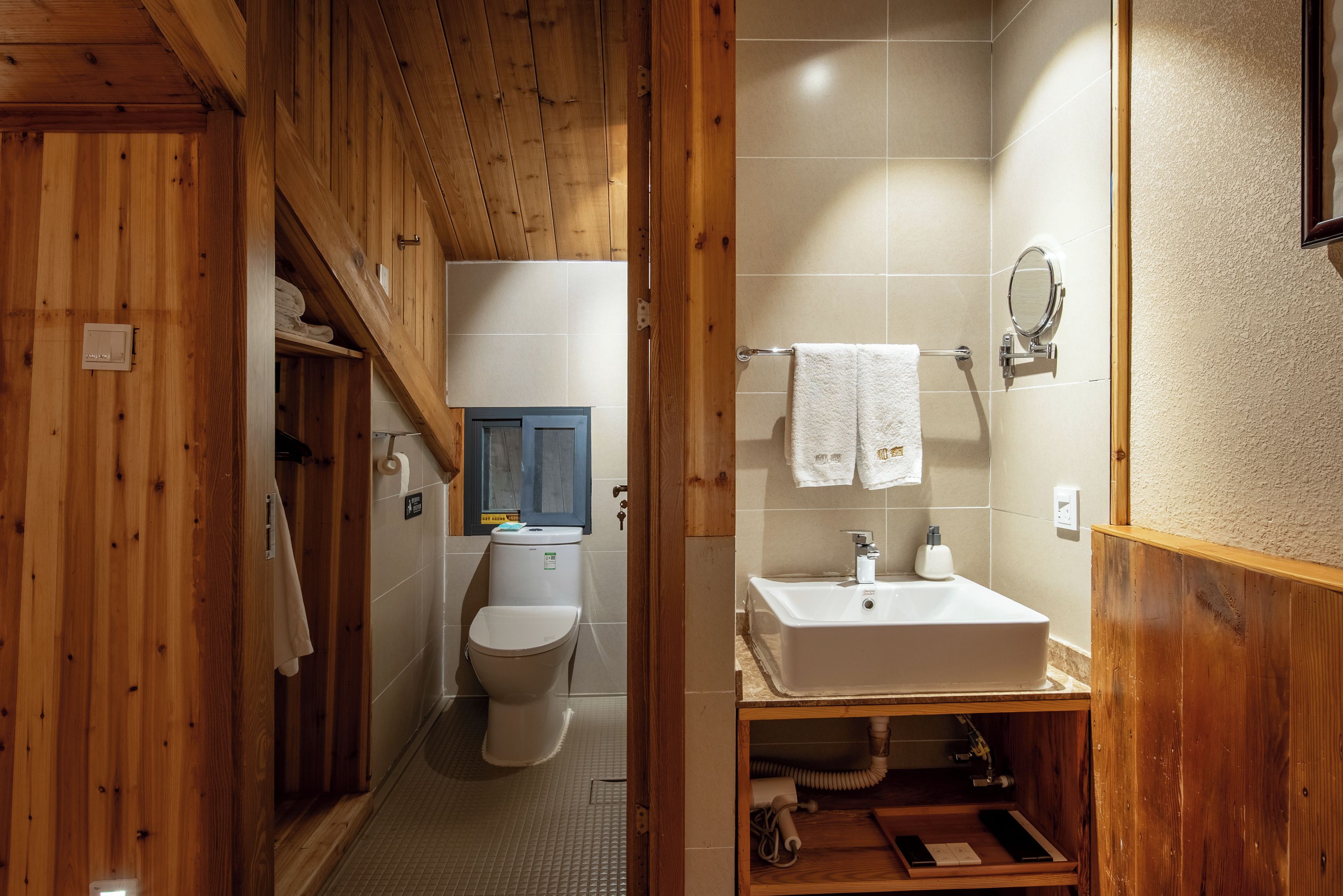 A compact bathroom with a toilet, sink, and shower area.