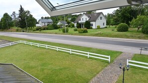 A view of a road with a white fence and a lamp post.