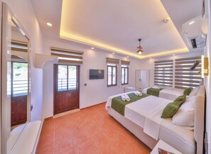 A hotel room with a bed, a television, a wardrobe, and a bathroom. - Kaşhan Hotel (Kas)