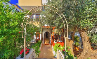 Un espacio al aire libre techado con una recepción, un camino que lleva a una entrada y un árbol.