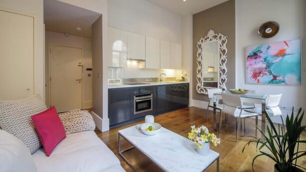 A modern living room with a sofa, a coffee table, and a dining area with chairs and a table. - Chic 1-bedroom apartment with WiFi, AC in fabulous london Muslim douche 4 people (London)