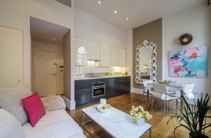 Un salon moderne comprenant un canapé, une table basse et un coin repas avec des chaises et une table.
