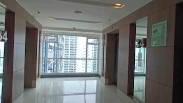 A corridor with a view of high-rise buildings through large windows.