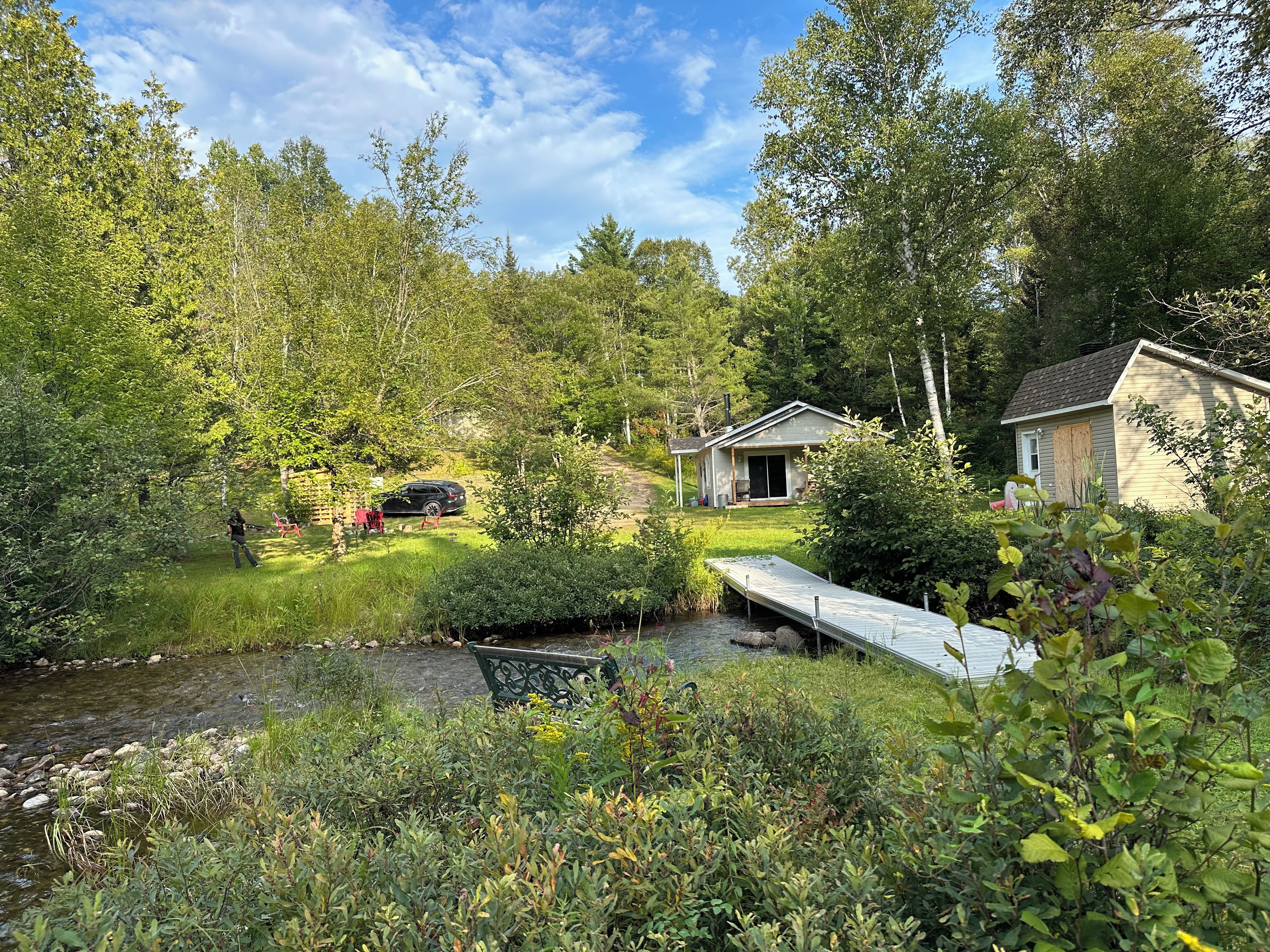 En ejendom med hus, bådebro og å.