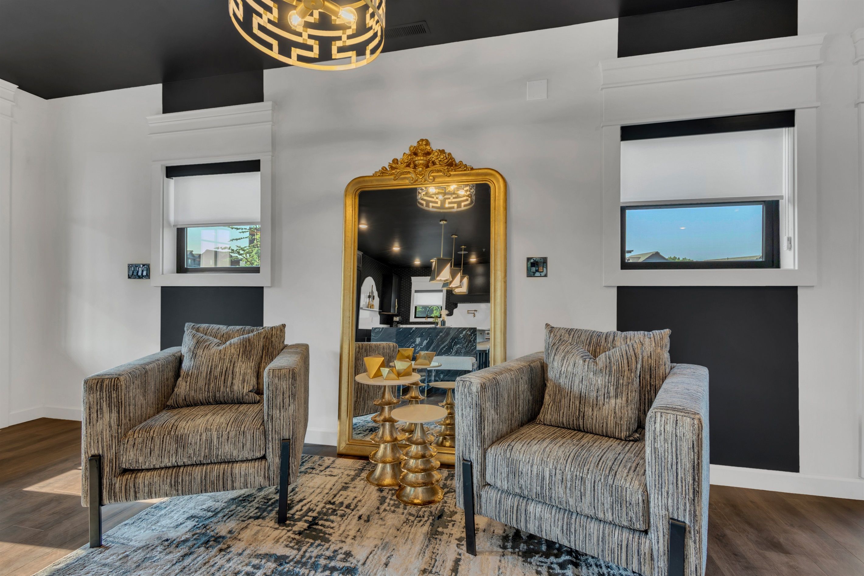 A modern living room with two armchairs, a large mirror, and a unique coffee table.