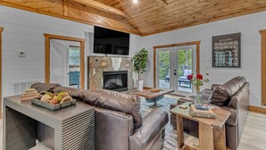A cozy living room with a fireplace, leather sofas, and a television. - New!Min Away from Gatinburg,Pool Table, (Gatlinburg)