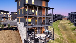 A multi-story building with balconies, outdoor seating, and a view of the surrounding landscape. - Smoky Mtn Luxury Cabin, FREE Waterpark, PS5, Pool Table, Indoor Pool, Mini Golf (Sevierville)