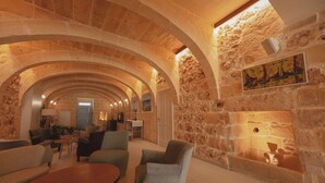A stone-walled interior with arched ceilings, a fireplace, and seating areas. - Silla Boutique B&B (Xagħra)