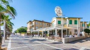 A street with a café named "La Barca" featuring outdoor seating and a signboard. - Nice apartment for 5 guests with A/C, WIFI, TV, patio and pets allowed (Cecina)