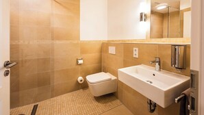A bathroom with a shower, toilet, and sink.
