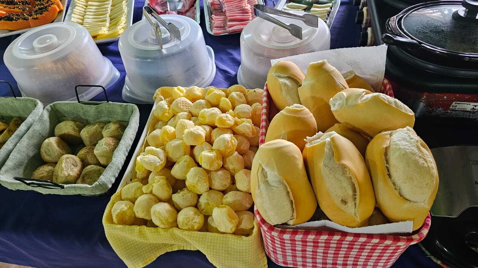 A buffet table with various food items including bread rolls, cheese, and other baked goods.