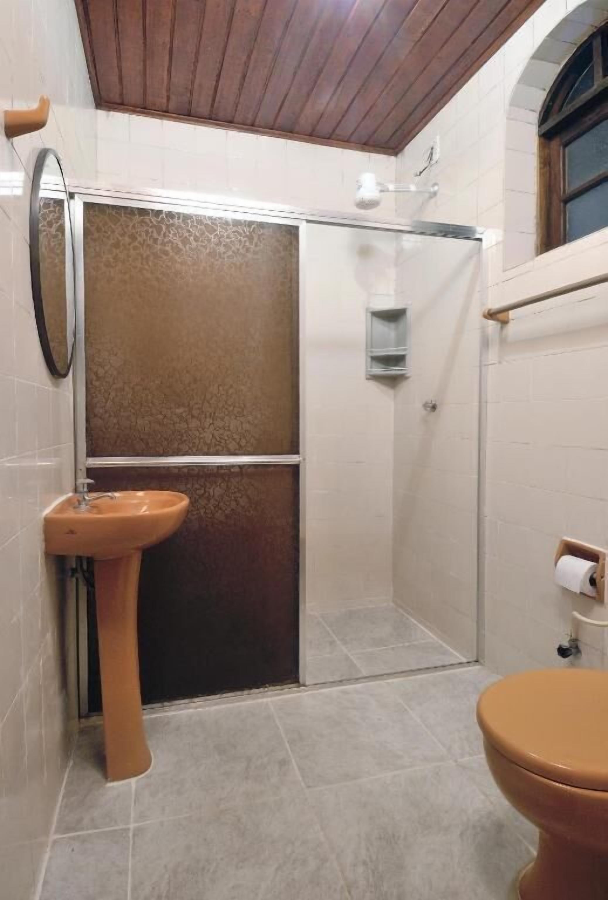Een badkamer met een douche, wastafel en toilet.
