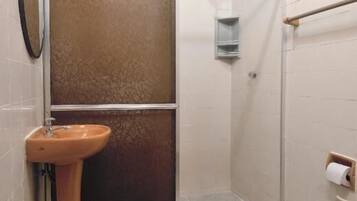Een badkamer met een douche, wastafel en toilet.