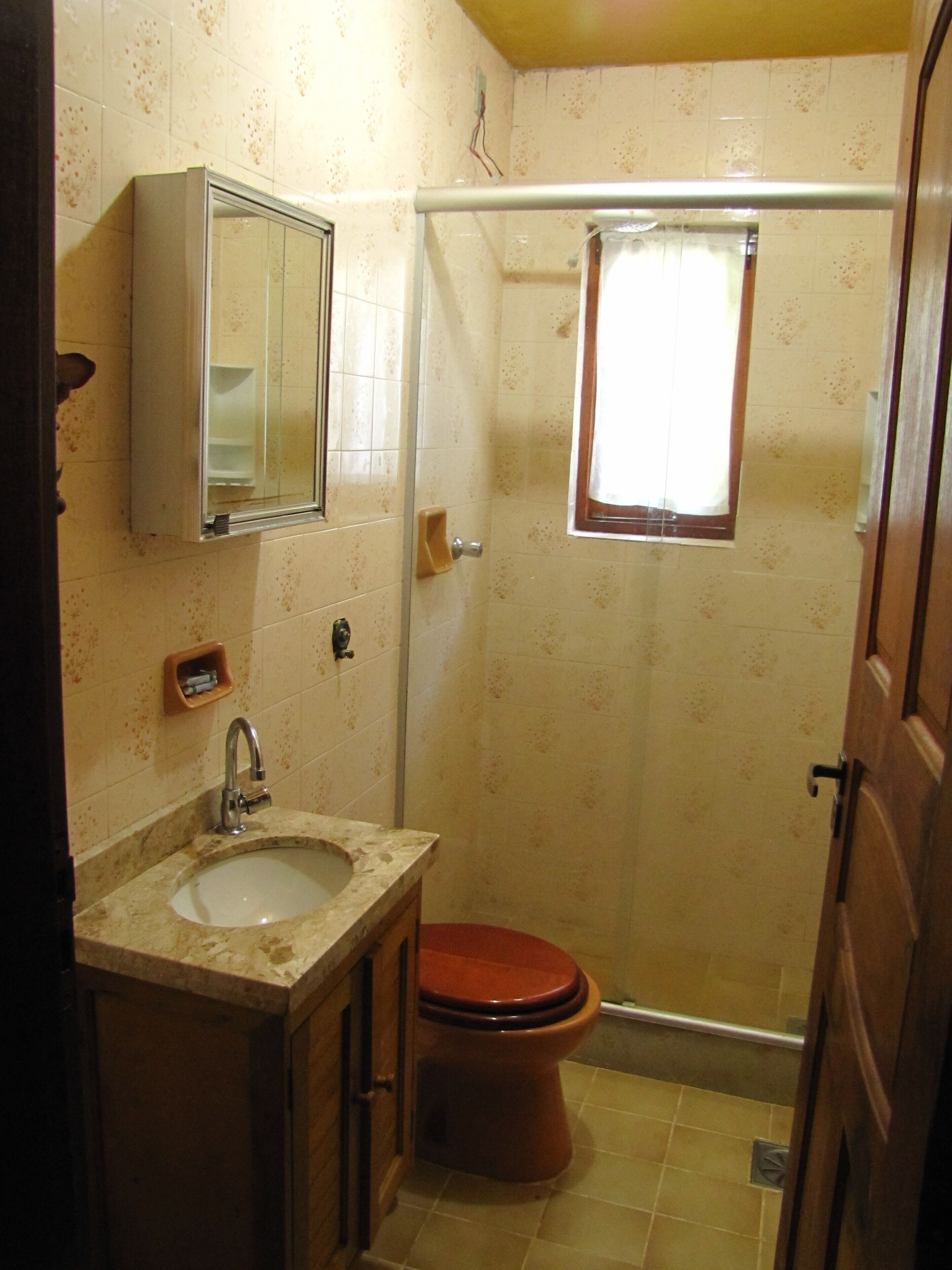A small bathroom with a sink, mirror, toilet, and shower.