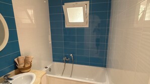 A bathroom with a bathtub, a sink, and a mirror. - Villa mayline (Arkou)