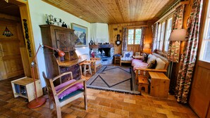 Una sala de estar acogedora con chimenea, muebles de madera y una alfombra.