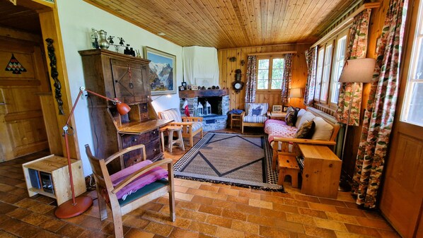 Una sala de estar acogedora con chimenea, muebles de madera y una alfombra.