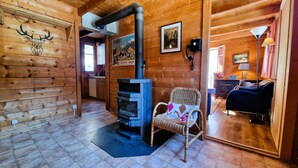A cozy log cabin interior with a fireplace, wooden walls, a dining area, and a living room. - Chalet Dar El Jebel - 6 personnes (Evolène)