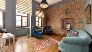 Una sala de estar con pared de ladrillo, chimenea y sillón azul.