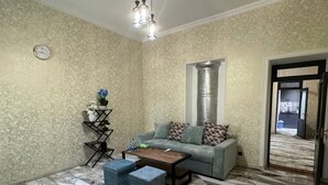 Una sala de estar con piso estampado, un sofá, una mesa de centro y una lámpara decorativa.