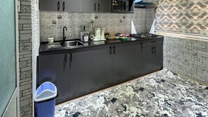Una cocina moderna con armarios oscuros, un microondas y una estufa a gas.