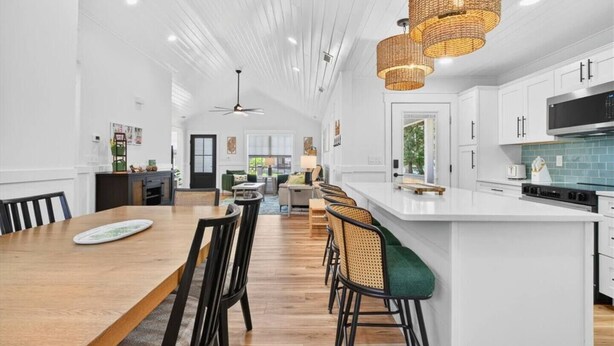 Une cuisine spacieuse dotée d’un grand îlot central, de meubles blancs et d’une cuisinière moderne.