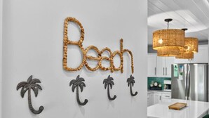 Un mur orné du mot « Plage » et de décorations en forme de palmiers.