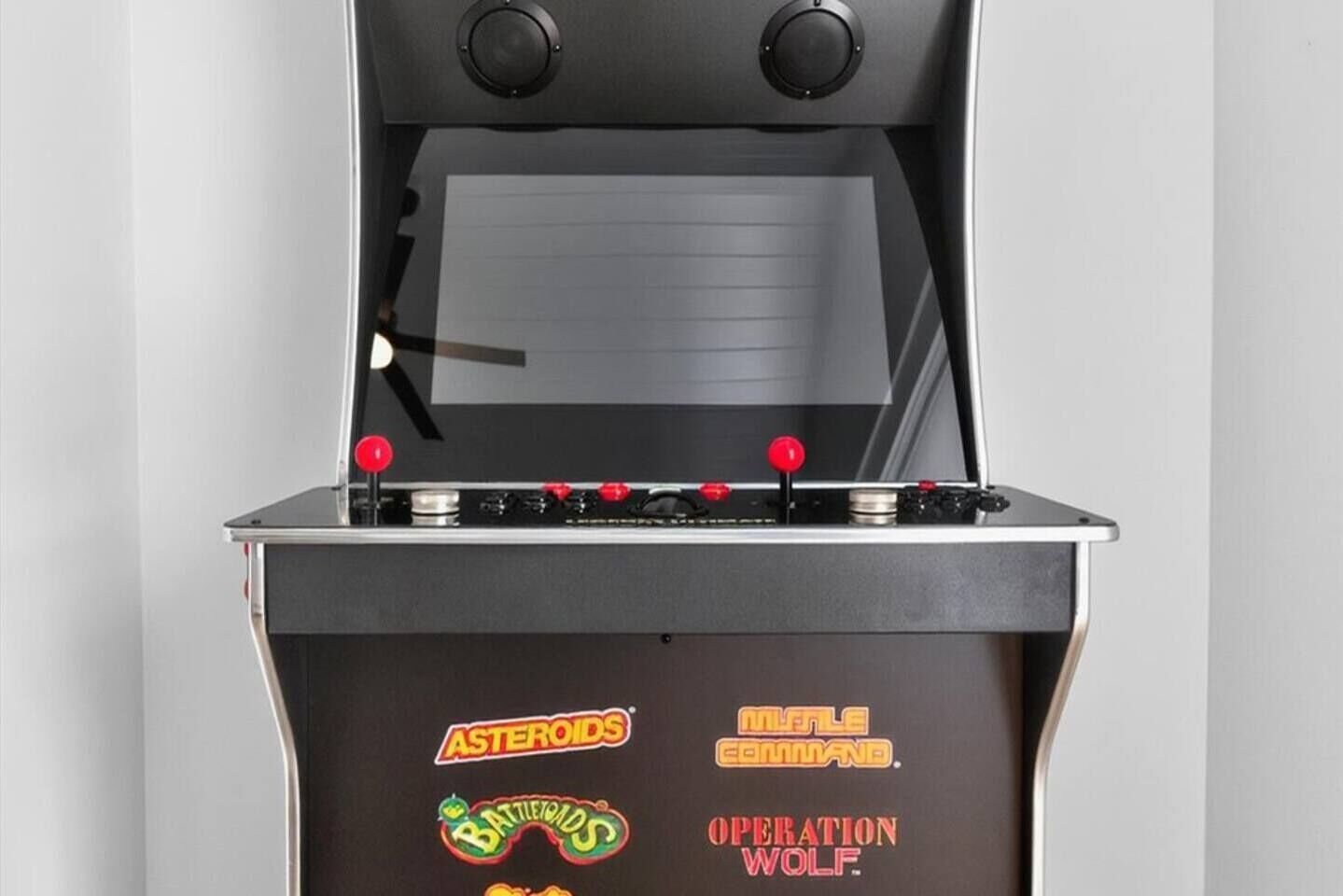 A retro arcade machine with joystick controls and game labels.