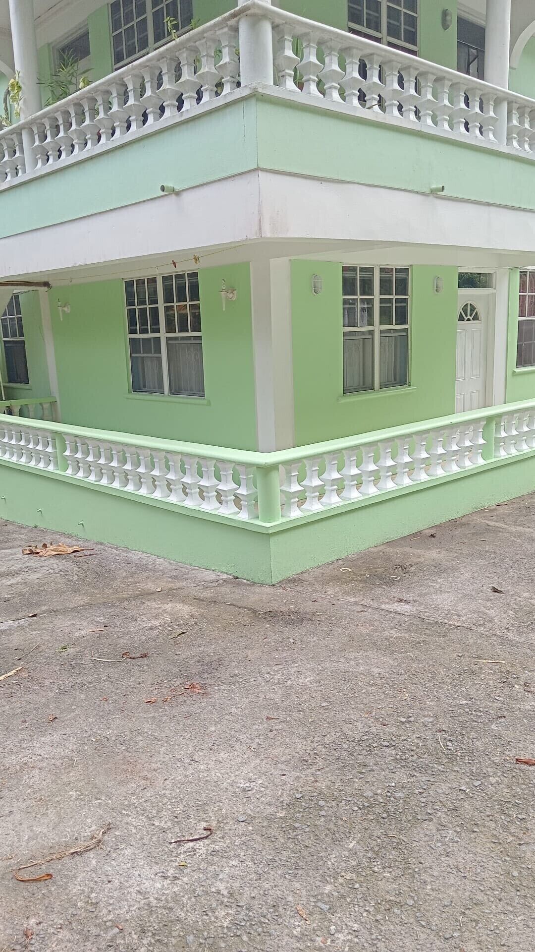 A two-story building with a green facade and white trim.
